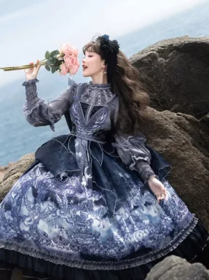 Ink blue gothic lolita dress with white floral print, sheer puff sleeves, and ruffled hem, side view on model at coastal rocky beach wearing black flower hair accessory