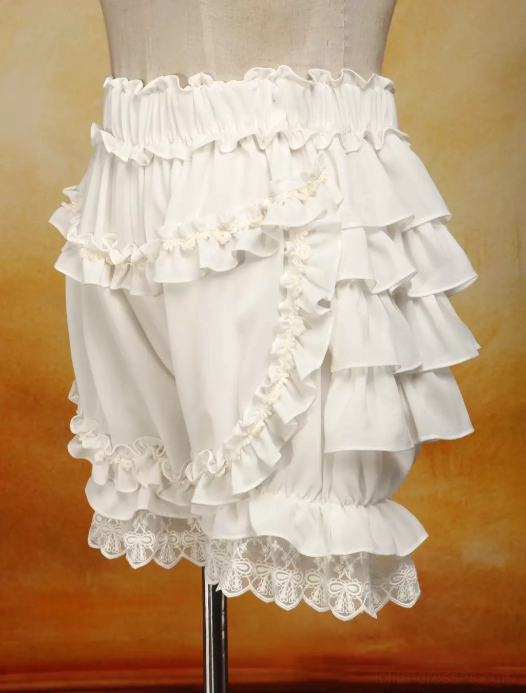 Left side view of ivory chiffon bloomers displaying multi-layer ruffled leg design, side ruffled straps, and lace-trimmed hems on dress form