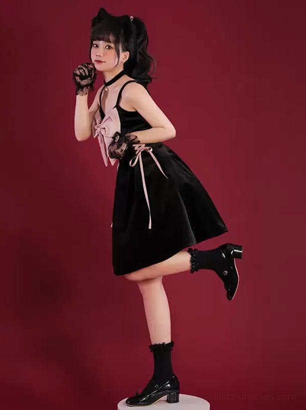 Black Jirai Kei slip dress with pink chest bow and side lace-up ribbons, three-quarter side view on model wearing block heel ankle socks