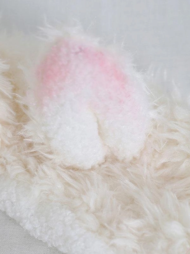 Macro close-up of lamb ear detail showing pink-to-white ombre plush material and soft fluffy surface texture
