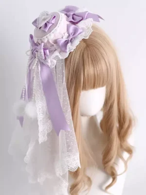 Sweet lolita lavender top hat headdress with layered dotted lace veil and fluffy pom-pom accents shown from front right angle on wig mannequin lolita fashion accessory