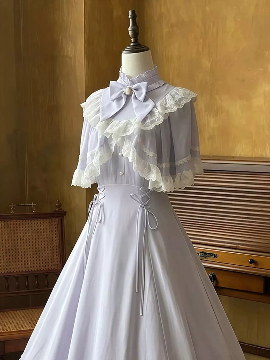 Full front view of classic lolita dress in soft lavender featuring stand collar, dual drawstring waist mechanism, lace capelet cape, and graceful maxi skirt with scalloped hem