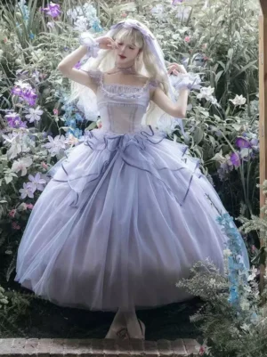 Full front view of lavender fairy lolita wedding gown featuring corset-style bodice, layered tulle bell skirt, white choker, and bow veil accessory, modeled outdoors in blooming flower field