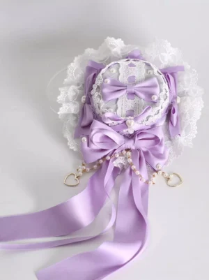 Lavender sweet lolita mini top hat hair clip with ruffled lace bow and pearl heart tassels - flat lay view