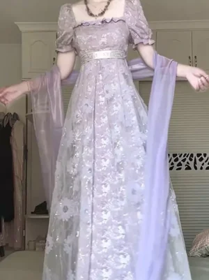 Lavender vintage lolita dress medium dynamic front view showing daisy floral applique, empire waist, wide sheer purple shawl drape, and romantic silhouette in indoor wardrobe setting