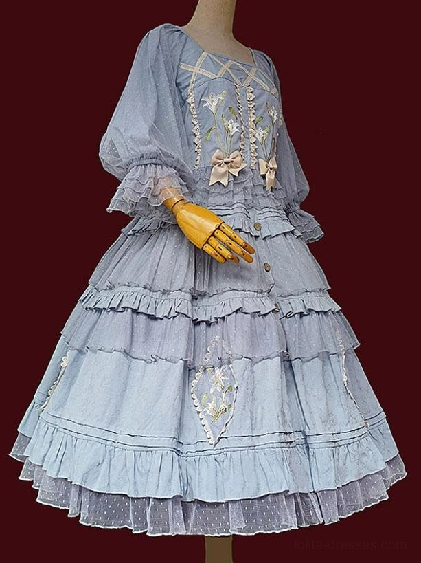 Light blue Classic Lolita dress front view on dress form showing square neckline puff sleeves floral embroidery and layered ruffled skirt with dotted tulle trim