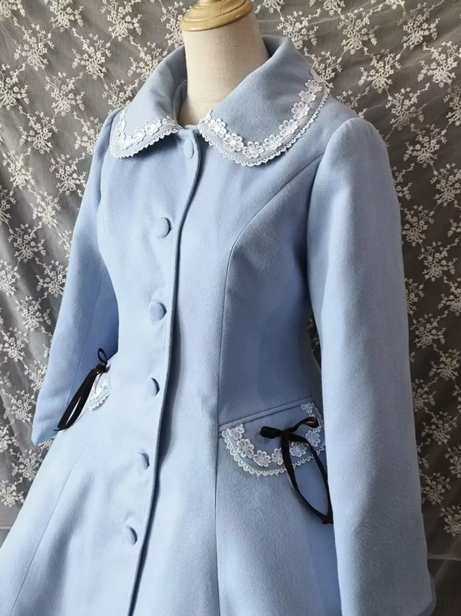 Close-up front partial view of light blue lolita coat showing lace-trimmed doll collar detail, front buttons, black ribbon pocket embellishment