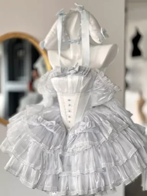Sweet lolita dress rear view showcasing layered tiered skirt, lace-up back details, light blue ribbon accents, and rabbit ear headdress