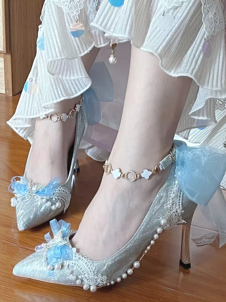 Light blue glitter Lolita pointed toe shoe with blue bow, pearl side trims and metal ankle bracelet on wood floor
