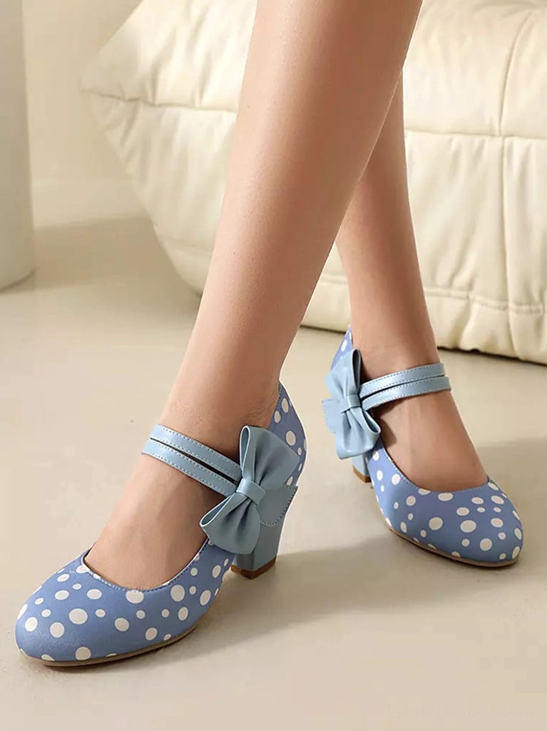 Light blue polka dot Mary Jane lolita heels on female model wearing vintage-style clothing - lower leg studio shot