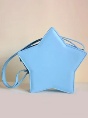 Light blue star-shaped lolita crossbody bag front eye-level shot with adjustable shoulder strap and matte leather finish displayed on gradient warm background