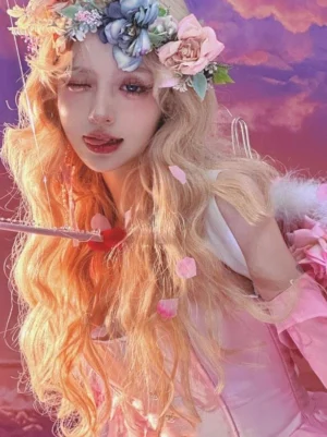 Light gold long wavy lolita heat-resistant wig front view with flower crown and pink sunset fantasy backdrop showing gradient blonde hair and pink rococo lolita outfit perfect for sweet lolita aesthetic and tea party fashion