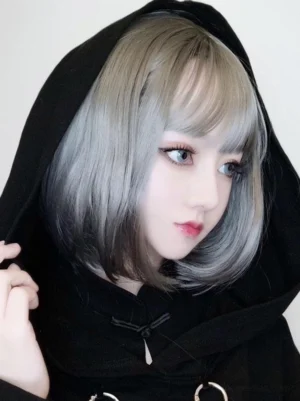 Light gray short bob lolita wig with blunt bangs styled in left three-quarter profile view on female model wearing black hooded gothic coat