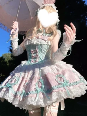 Light green sweet lolita jumper dress front view outdoor with blonde model holding lace parasol and wearing matching accessories in sunny garden setting