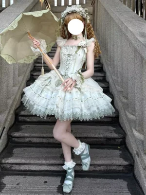 Light green sweet lolita princess dress with lace-up corset bodice, featuring voluminous ruffled tulle skirt, short puffed sleeves, and layered lace trim details, modeled outdoors on stone stairway with vintage parasol accessory and complete coordinate