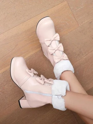 Light pink Lolita ankle boots top-down view on wooden floor displaying double bows, plush fur trim, side zipper, and block heel construction