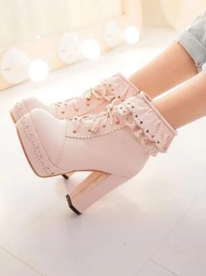 Light pink Lolita ankle boots side profile view worn on model legs, featuring thick block high heel and hollowed ruffled trim design