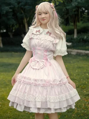 Light pink Sweet Lolita cotton jumper dress full front view on model, featuring puff sleeves, corset bodice, and pink bow accents