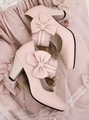 Light pink Lolita Mary Jane pumps flat lay top-down view showing dual fabric bows, closed round toe design, and smooth matte PU leather texture on pearl-decorated background