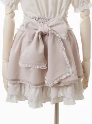 Light pink ruffled sweet lolita skirt with large front bow and lace-trimmed layered hem full front view on dress form