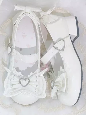 Top-down flat lay view of light sky blue Lolita block heel pumps on soft lace fabric background, displaying heart buckle ankle straps, front butterfly bow with heart ornament, and rear heel bow accents