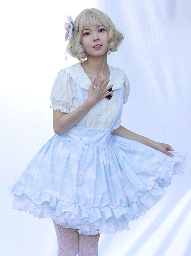 Front partial view light sky blue pastoral lolita skirt with lifted flared silhouette, delicate floral print fabric, ruffled hem detail, hand-on-chest pose modeling shot