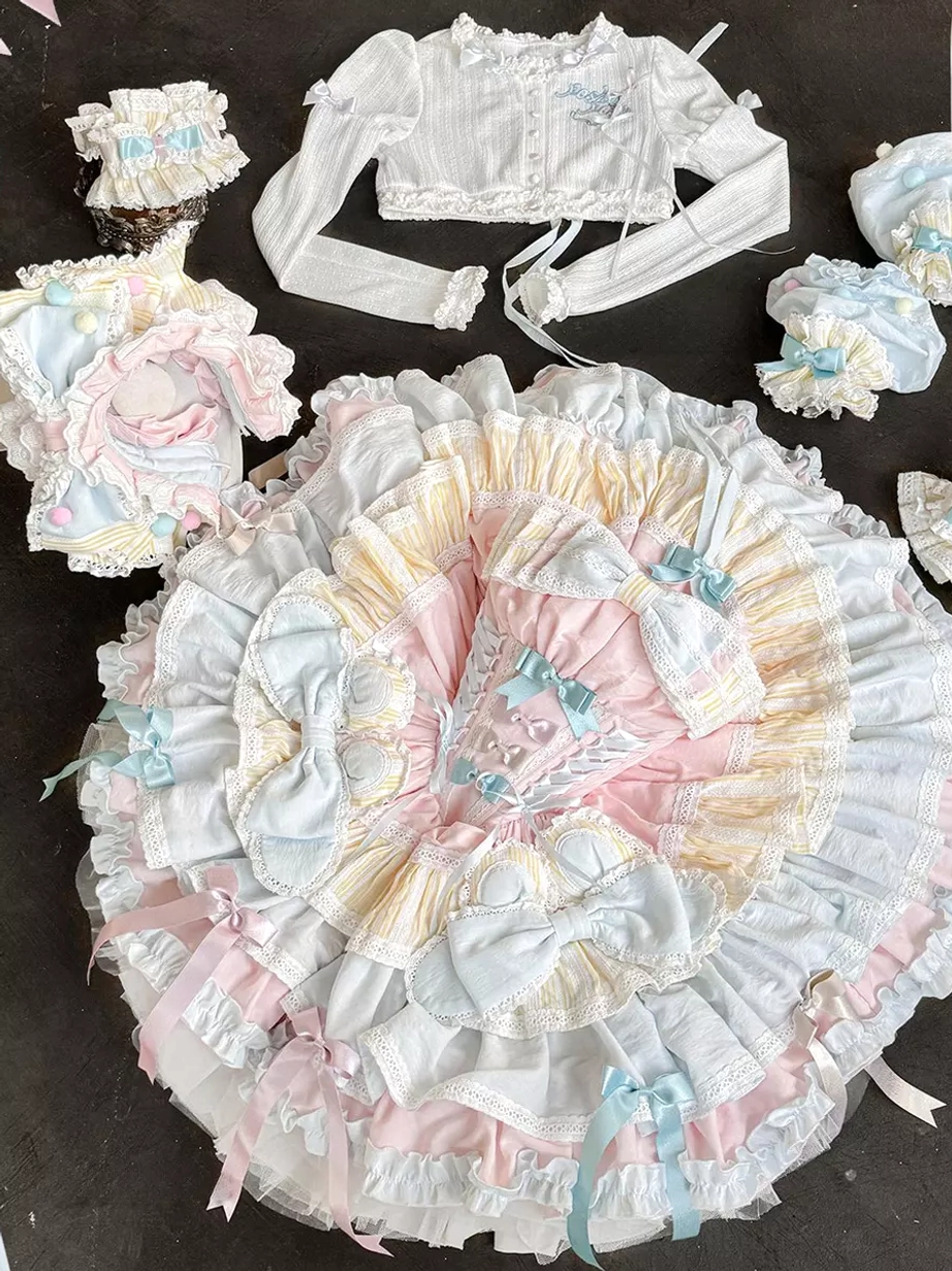 Full Lolita 5-piece suit components flat lay top-down dark table background including skirt cropped jacket hair accessories ruffled trims complete set