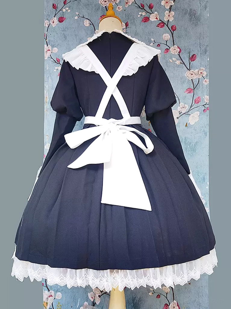 Lolita apron back display on dress form with large white waist bow and cross apron straps floral wallpaper background