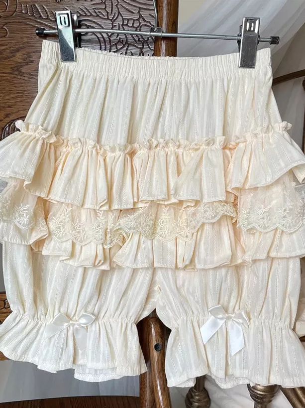 Lolita bloomers shorts collection showing ruffle details elastic waist construction and decorative bow elements close-up view