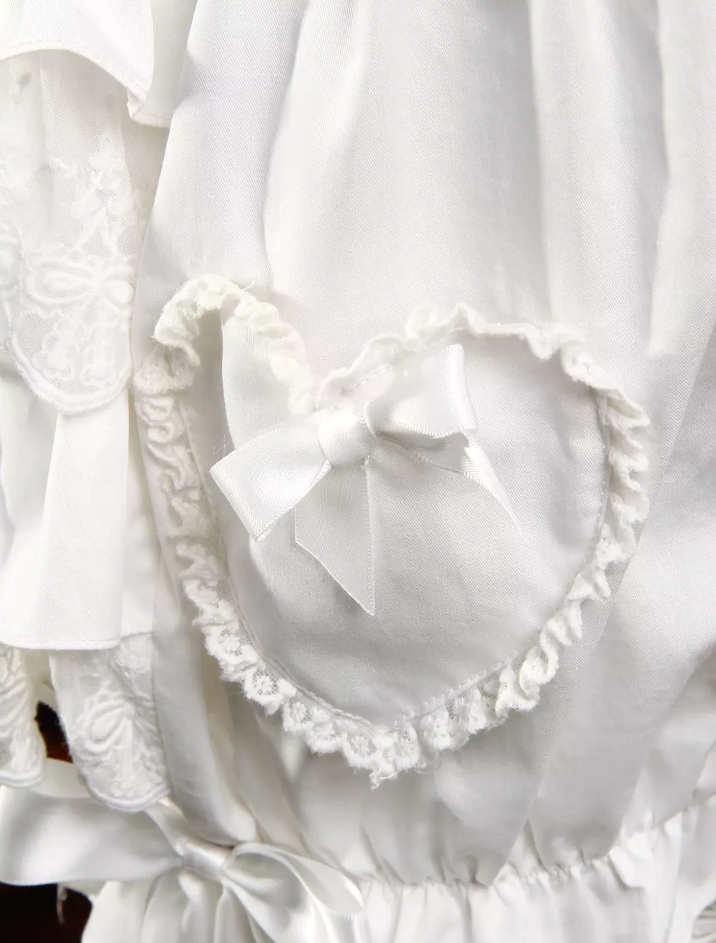 Lolita bloomer close-up detail showing heart-shaped ruffled pocket satin bow and delicate lace embroidery embellishment