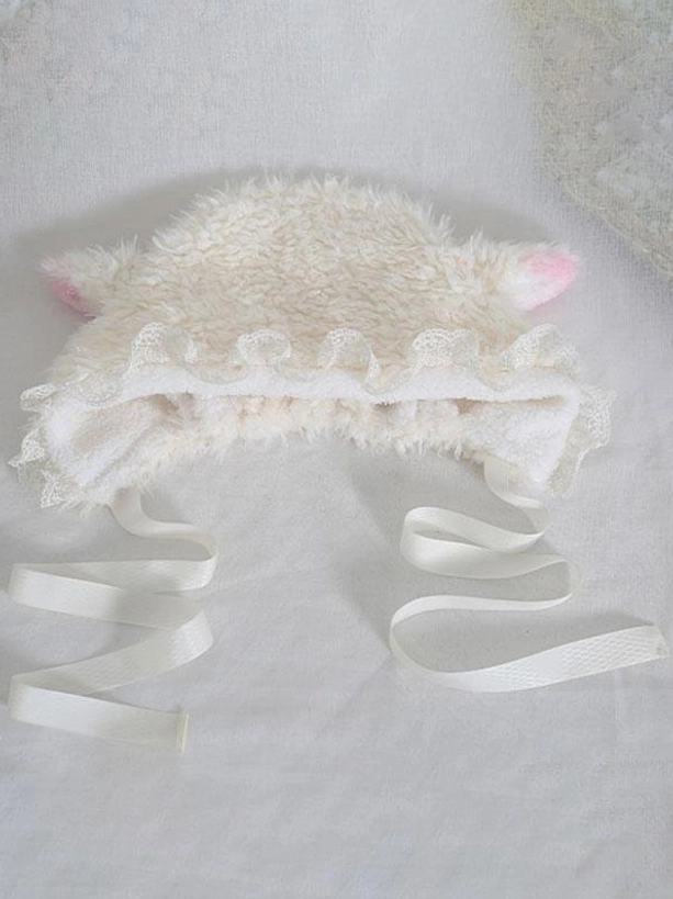 Flat lay top-down view of Lolita lamb ear bonnet showing off-white plush material pink-tipped ears and long satin ribbon ties