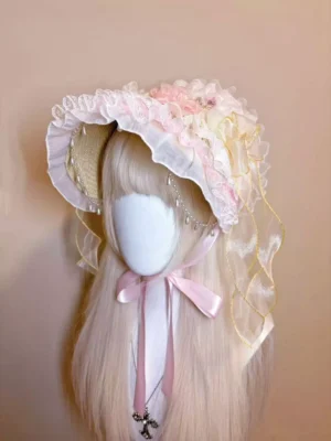 Lolita bonnet headdress front view featuring delicate pearl face chain, sheer gold ribbons, floral lace trim, and romantic pink aesthetic on mannequin model