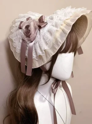 Sweet lolita bonnet headdress front side angle view featuring straw-woven brim edge, layered lace ruffles, central mauve floral bow ornament, and romantic ribbon details on mannequin model