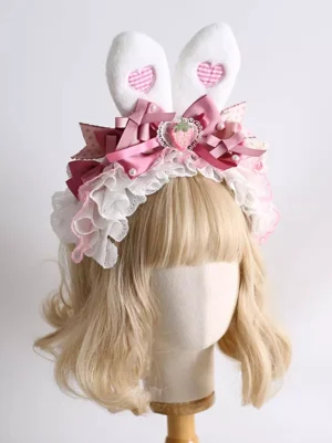 Matching Lolita bunny ear hair accessory three-quarter front view on wooden display stand, showcasing layered pink ribbons and full frilled lace trim detail