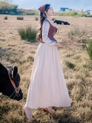 Vintage lolita two-piece dress side profile showing high-waisted silhouette lace-up wine corset vest and flowing cream skirt with natural countryside backdrop