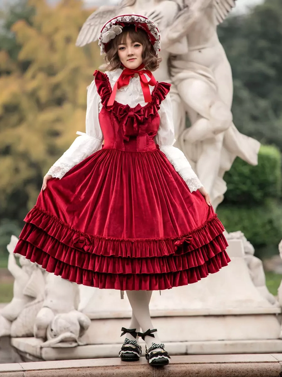 Sweet lolita burgundy JSK dress full side profile showing ruffled double-layer hem and sleeveless design, worn with lace bonnet and white stockings
