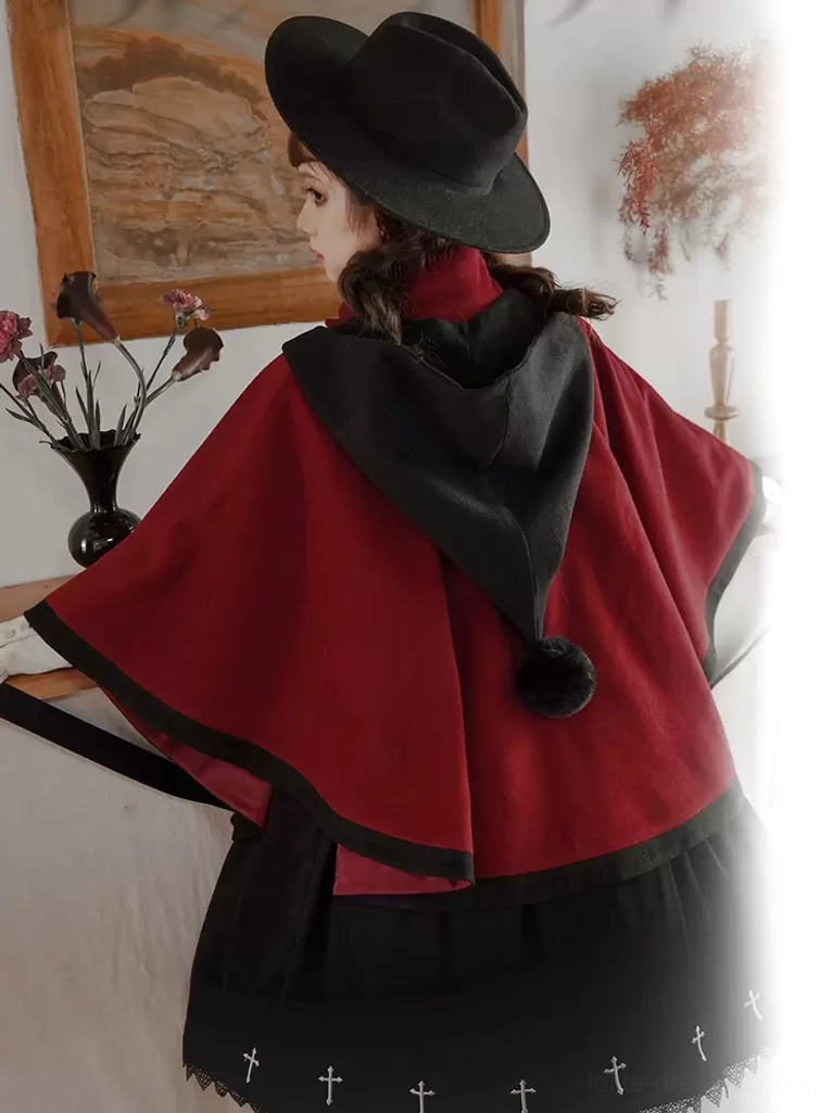 Vintage-inspired styling photograph of two-tone Lolita cape coat with statement velvet bow, shown with period-appropriate accessories and headwear