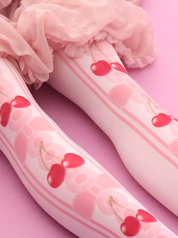 Lolita knee-high cherry printed stockings side close-up detail showing pink lace bow patterns soft fabric texture and red cherry designs against pink background