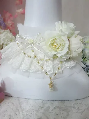 Side view of ivory lolita choker featuring delicate ruffled lace, silk roses, satin ribbon bow, beaded gold chain, and pearl drop accent