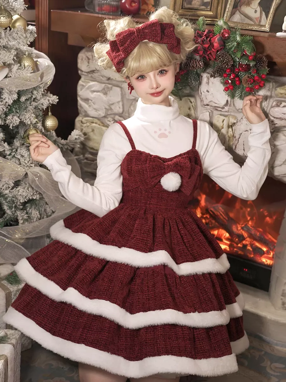 Three-quarter front view of Christmas lolita dress with inner high-neck top matching head bow and tiered ruffles near Christmas tree and fireplace