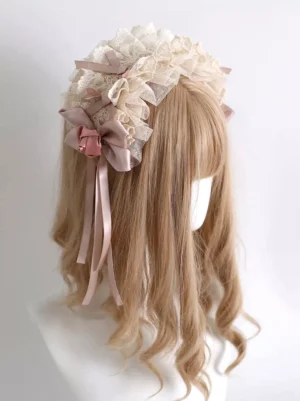 Lolita lace hairband side view showing ruffled cream lace, dual dusty pink bows with ribbon tails and small fabric flower accent detail