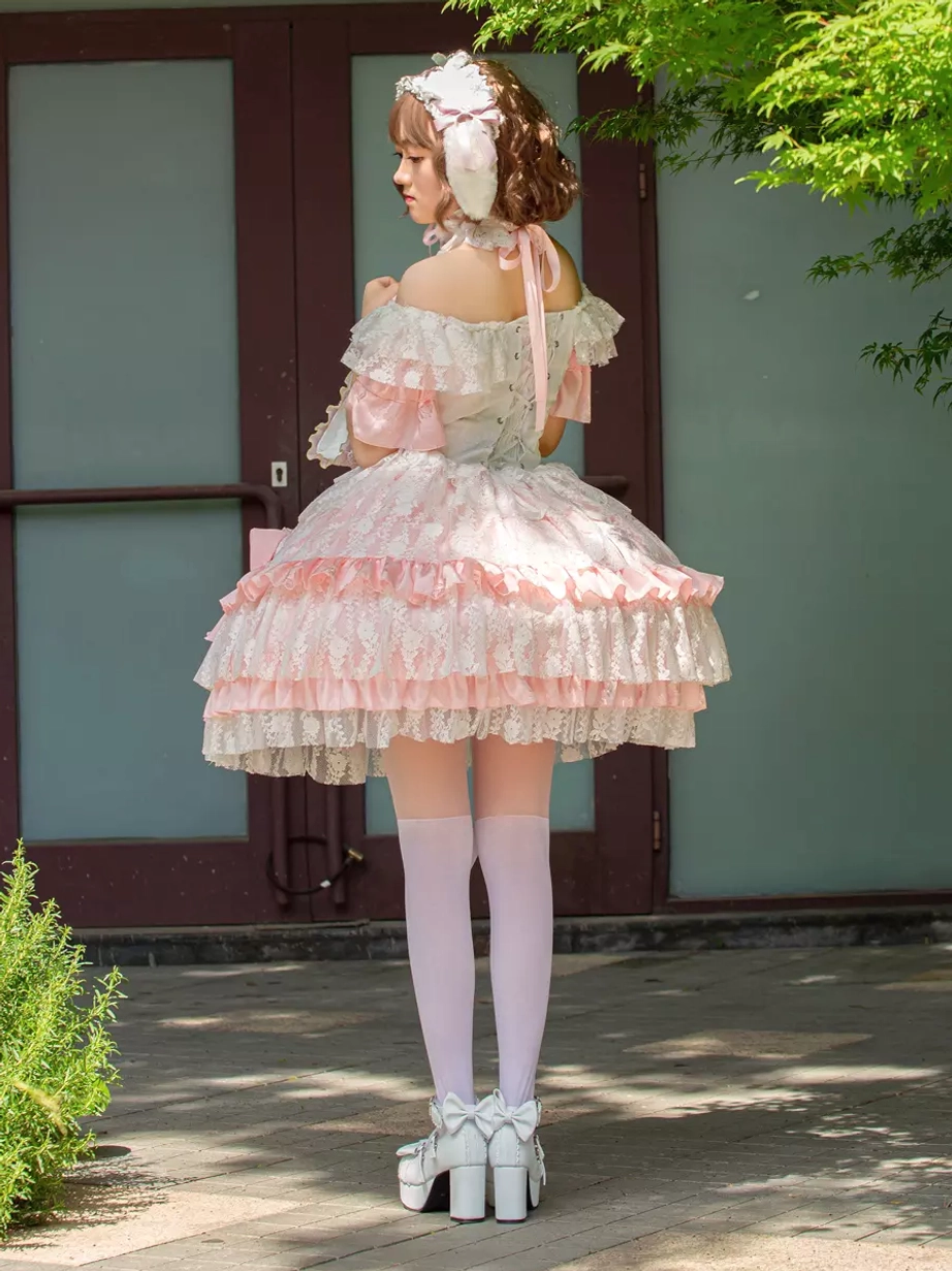 Lolita dress rear view with bow tie back detail layered lace skirt and thigh-high white stockings outdoor glass door
