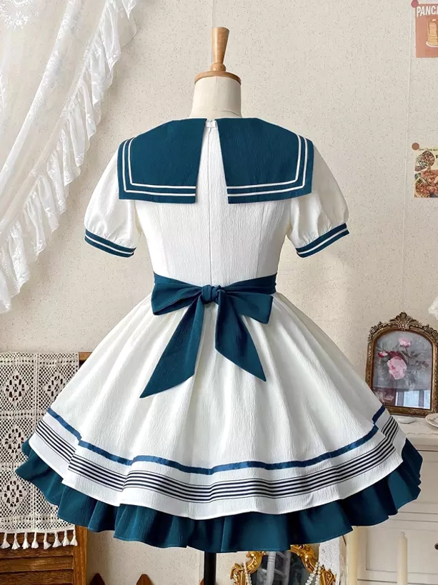 Navy sailor lolita dress back view on dress form showing large back waist bow sailor collar trim and ruffled striped hem