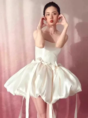 Ecru white lolita mini dress with puffed bubble skirt and dual front bow embellishments posed modeling shot