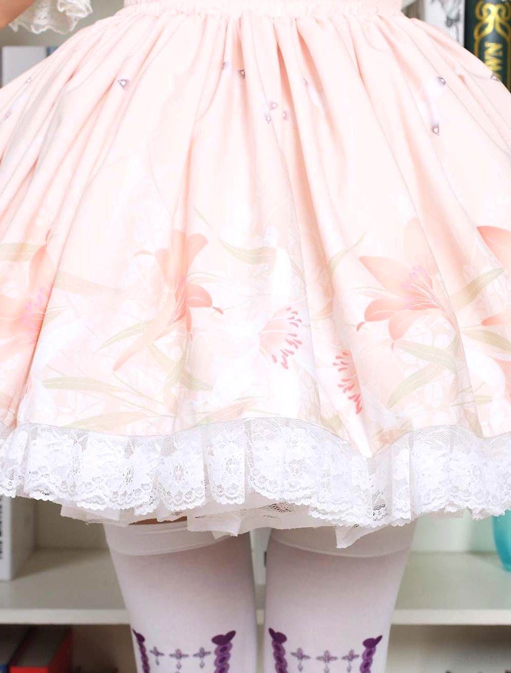 Pink floral print lolita dress lower body close-up with lily flower pattern white lace hem and patterned socks