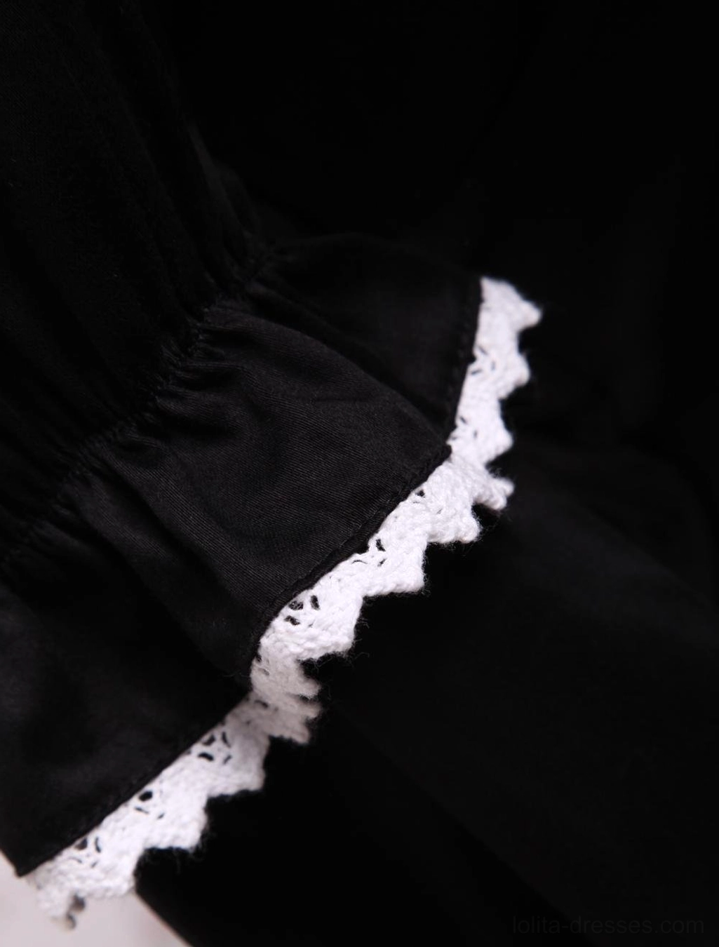 Close-up detail of black Lolita dress sleeve cuff featuring white scalloped lace trim and elasticated black fabric cuff