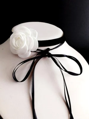 Delicate Lolita choker necklace featuring white fabric rose, black velvet strap, and extended satin bow ties, mannequin neck styling detail