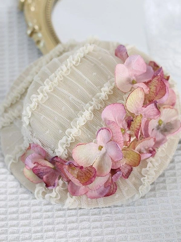 Top-down flat lay of off-white mesh Lolita hair accessory with mixed pink-brown gradient hydrangea blooms and ruffled lace edging