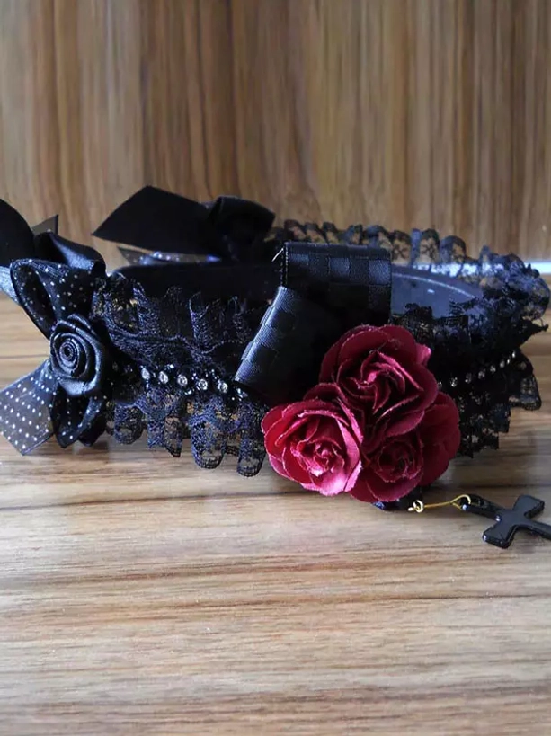 Lolita headdress flat lay product shot displaying full black lace band checkered bows wine red roses detachable cross pendant wooden surface