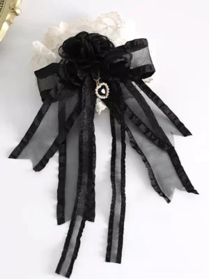 Single Lolita hair clip accessory black and ivory lace-up design with ruffled organza ribbon and pearl drop pendant flat lay top view